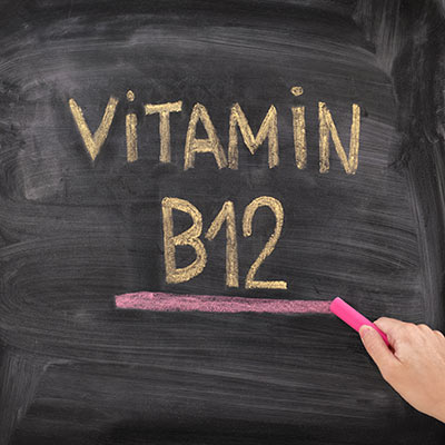 Vitamin B12 chalk text on blackboard with pink underline – high-contrast close-up