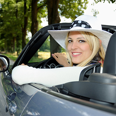 Blonde Frau mit Hut fährt Cabrio auf Landstraße – Symbol für Freiheit, Leichtigkeit und Sommergenuss