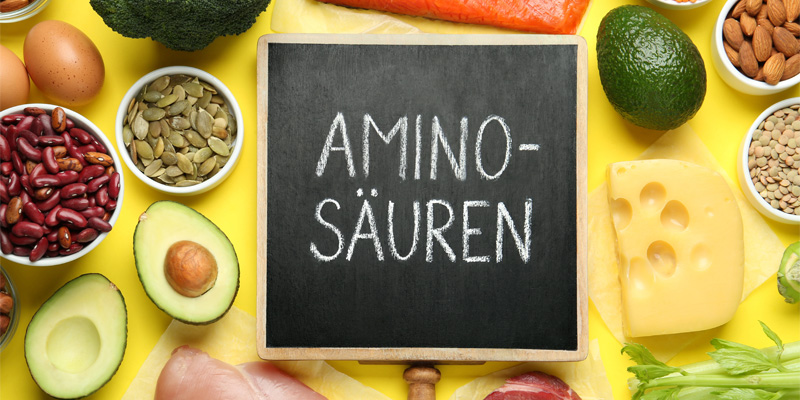 Tafel mit „Aminosäuren“ zwischen Avocado, Hülsenfrüchten, Käse und Samen – helle Food-Aufnahme