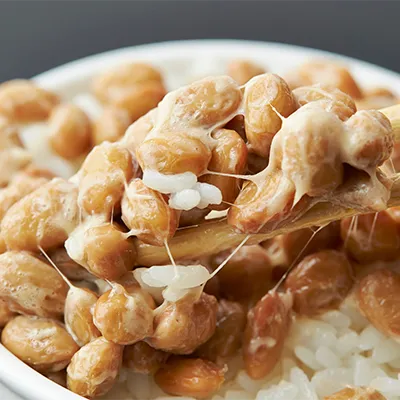 Close-up of natto, fermented soybeans with characteristic sticky strands on rice – natural source of vitamin K2