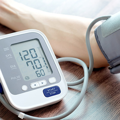 Blood pressure monitor on arm shows 120/70 – bright image of a blood pressure check