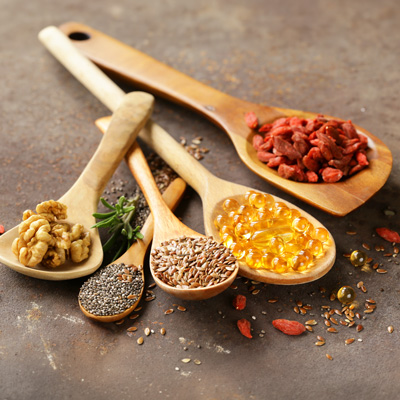 Verschiedene Samen, Nüsse und Kapseln auf Holzlöffeln – weiches Licht, natürliche und vielseitige Lebensmittelaufnahme