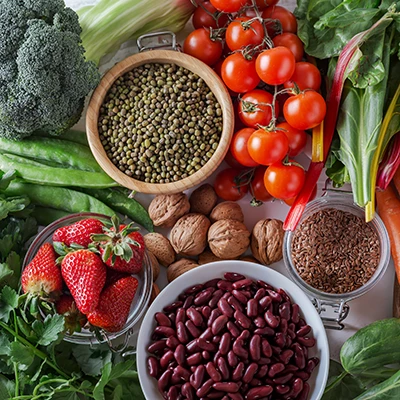Broccoli, legumes, tomatoes, strawberries and leafy greens as a selection of folate-rich foods