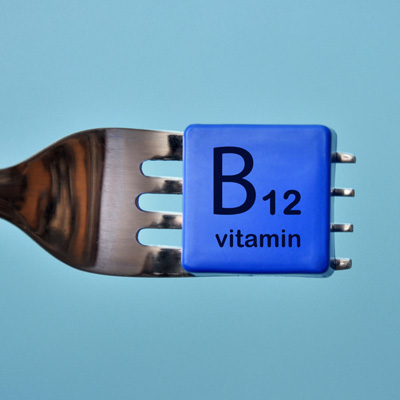 Vitamin B12 symbol on a cube on a fork – modern illustration against a blue background